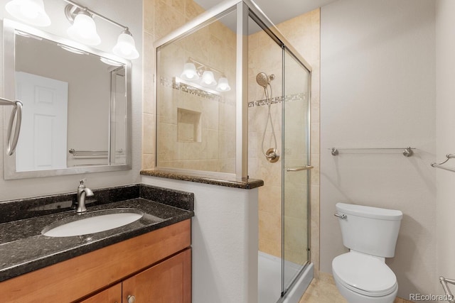 bathroom featuring a shower stall, toilet, and vanity