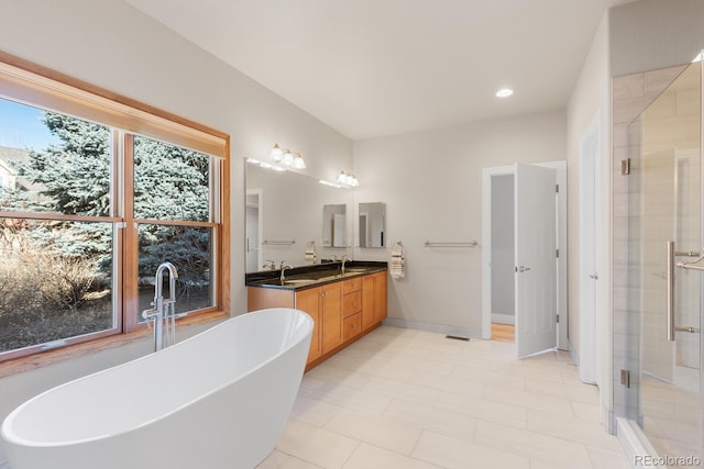 full bath with a wealth of natural light, a soaking tub, a stall shower, and double vanity