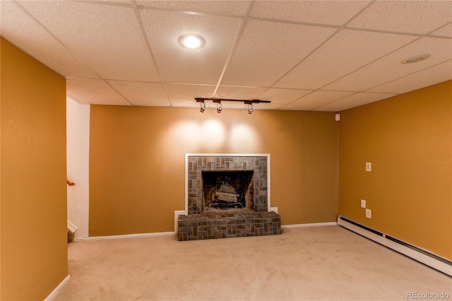 16291 E 7th Dr, Aurora, CO 80011 - unfurnished living room featuring baseboard heating, carpet flooring, baseboards, a drop ceiling, and a stone fireplace