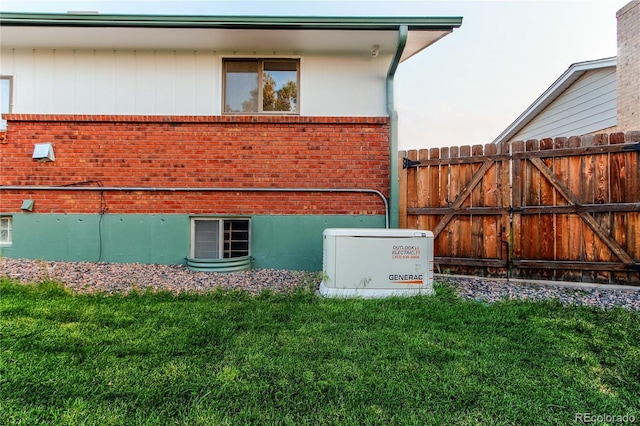 16291 E 7th Dr, Aurora, CO 80011 - view of home's exterior featuring brick siding, a yard, and a gate