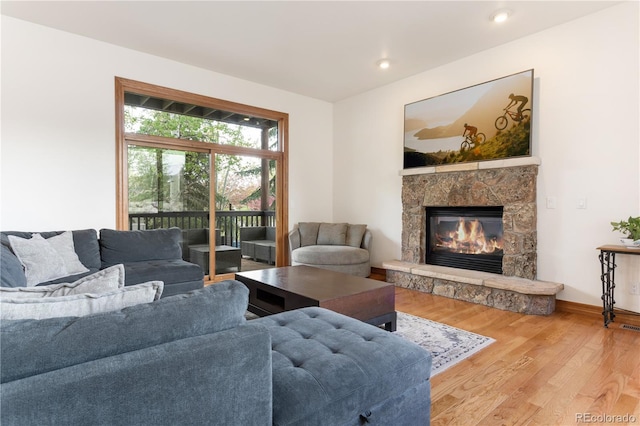 living room featuring hardwood / wood-style flooring and a stone fireplace