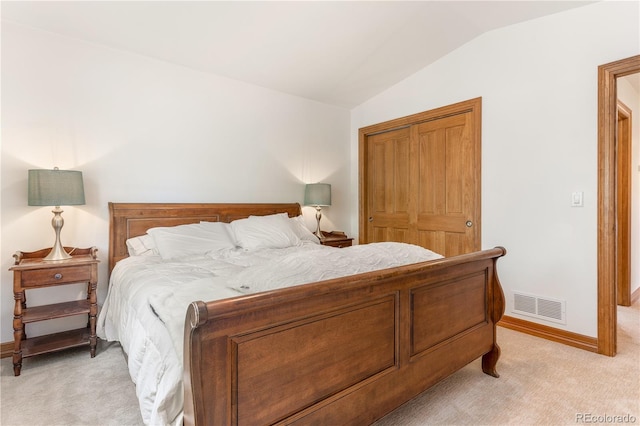 bedroom featuring lofted ceiling, a closet, and light colored carpet