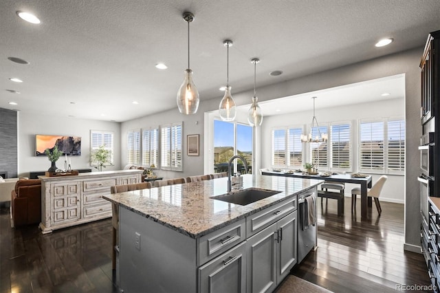 11046 Pastel Pt, Parker, CO 80134 - kitchen with a sink, open floor plan, dark wood finished floors, a center island with sink, and recessed lighting