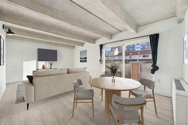 dining room featuring beamed ceiling, light wood-type flooring, and radiator