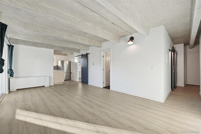 unfurnished living room with light wood-type flooring, a barn door, and beamed ceiling