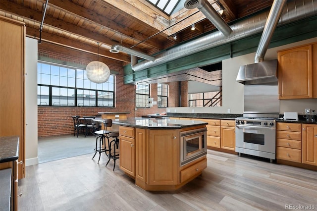 1515 N Ogden St Unit 7, Denver, CO 80218 - kitchen featuring wood ceiling, brick wall, appliances with stainless steel finishes, light wood-style floors, and wall chimney exhaust hood