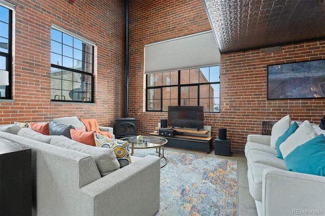 1515 N Ogden St Unit 7, Denver, CO 80218 - living room featuring concrete flooring, brick wall, a high ceiling, and a wood stove