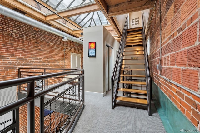 1515 N Ogden St Unit 7, Denver, CO 80218 - stairway with baseboards, carpet flooring, brick wall, and a skylight