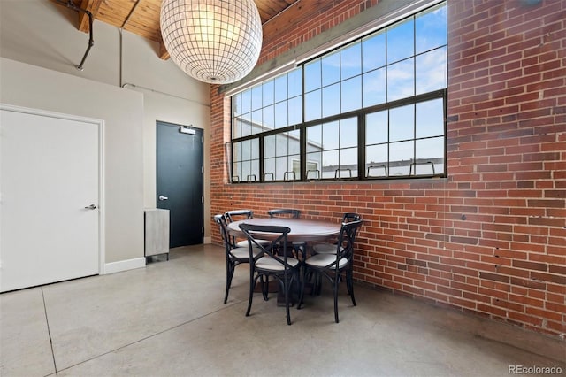 1515 N Ogden St Unit 7, Denver, CO 80218 - dining area featuring finished concrete floors, baseboards, a towering ceiling, and brick wall