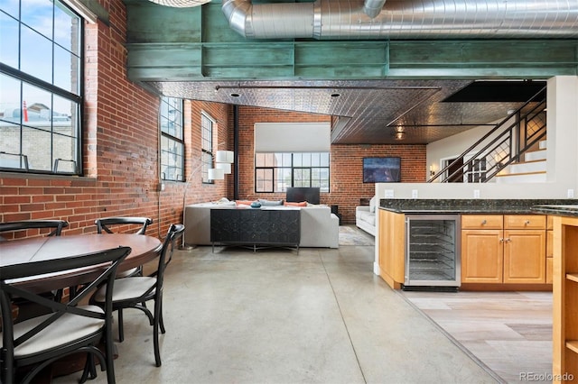 1515 N Ogden St Unit 7, Denver, CO 80218 - interior space featuring brick wall, finished concrete floors, light brown cabinetry, dark stone countertops, and wine cooler