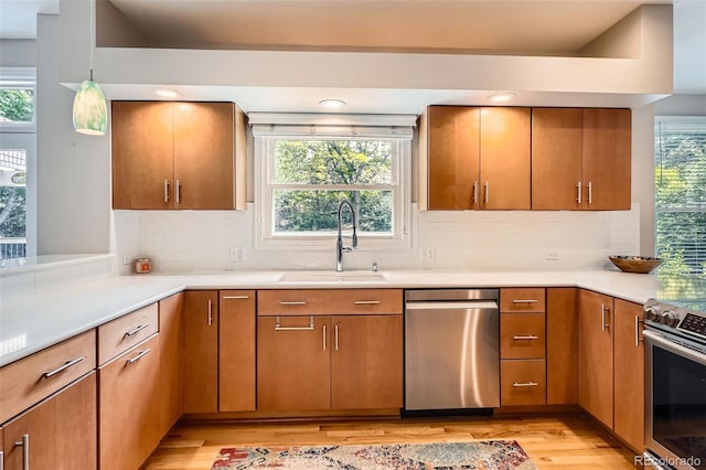 9962 Stratford Ln, Highlands Ranch, CO 80126 - kitchen featuring stainless steel appliances, light wood-style flooring, plenty of natural light, and light countertops