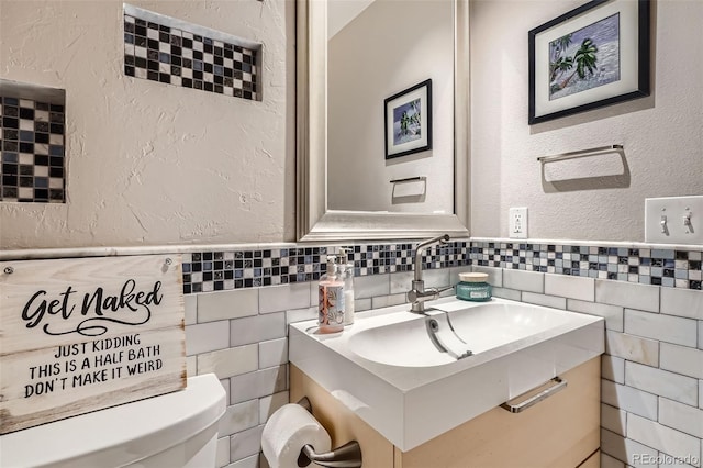 9962 Stratford Ln, Highlands Ranch, CO 80126 - bathroom with tile walls, vanity, a textured wall, and a wainscoted wall