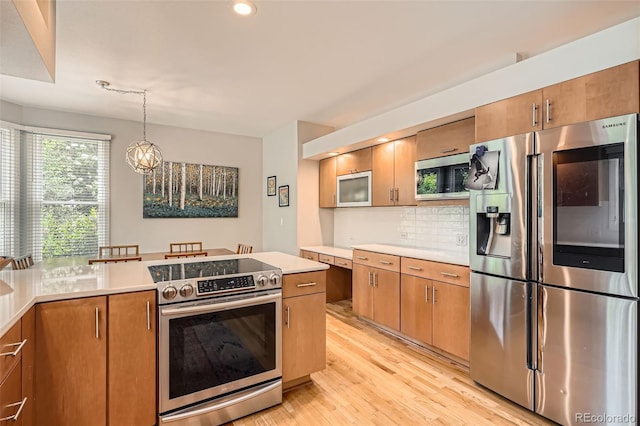 9962 Stratford Ln, Highlands Ranch, CO 80126 - kitchen with appliances with stainless steel finishes, light countertops, backsplash, light wood finished floors, and brown cabinetry