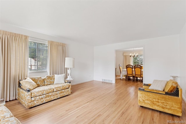 8484 E Radcliff Ave, Denver, CO 80237 - living area featuring wood finished floors, a chandelier, and baseboards