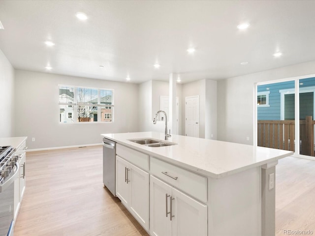 kitchen featuring sink, stainless steel appliances, light hardwood / wood-style flooring, a kitchen island with sink, and white cabinets