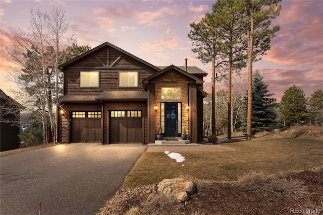 view of front of house with an attached garage, a shingled roof, and aphalt driveway