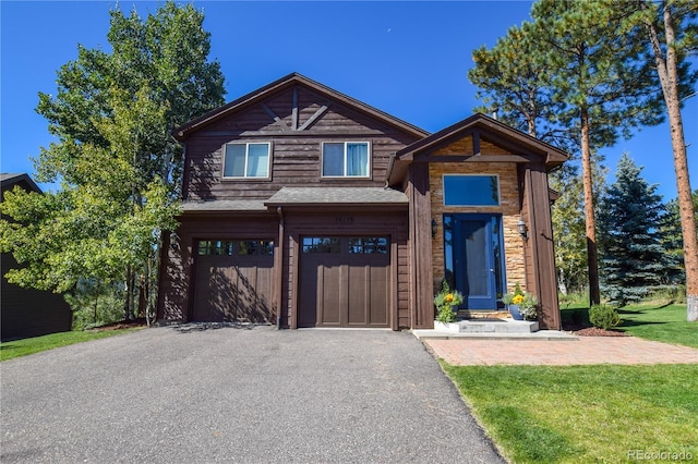 view of front facade featuring a garage, driveway, and a front lawn