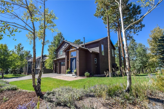 view of front of house featuring a garage, driveway, and a front lawn