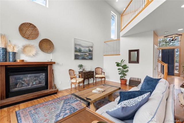 living area with a wealth of natural light, a high ceiling, and wood finished floors