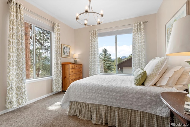 carpeted bedroom featuring baseboards and a notable chandelier