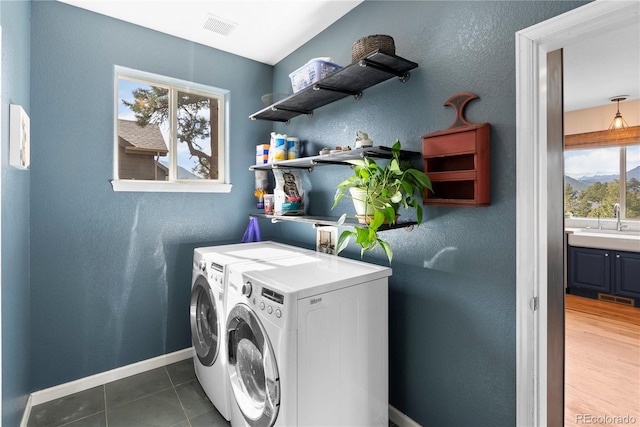 washroom with laundry area, baseboards, visible vents, and separate washer and dryer