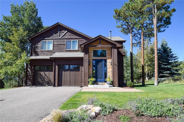 view of front of house with an attached garage, driveway, and a front lawn