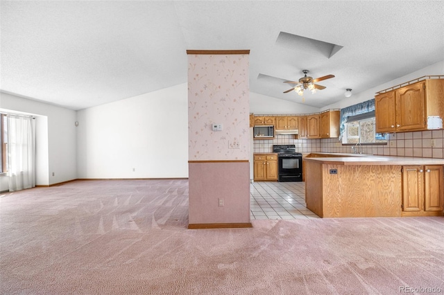 kitchen with black appliances, light carpet, open floor plan, and vaulted ceiling