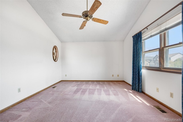 carpeted spare room featuring visible vents, ceiling fan, a textured ceiling, and vaulted ceiling