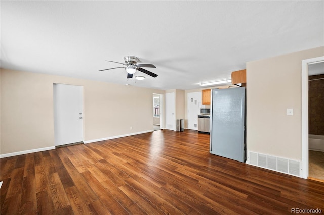 unfurnished living room featuring visible vents, dark wood-type flooring, baseboards, and ceiling fan