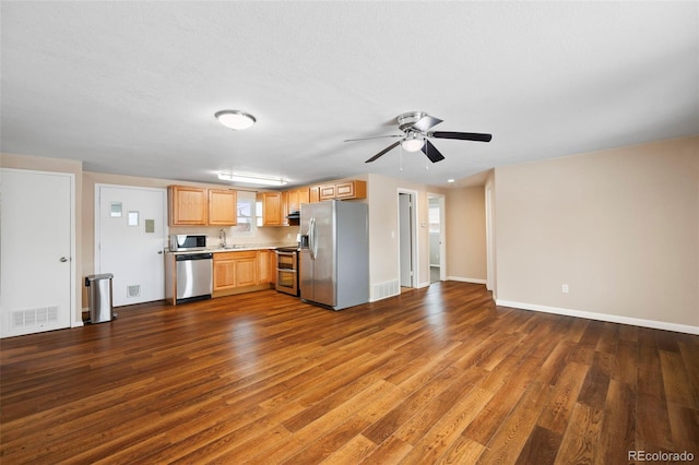 kitchen featuring a sink, dark wood finished floors, light brown cabinets, and stainless steel appliances