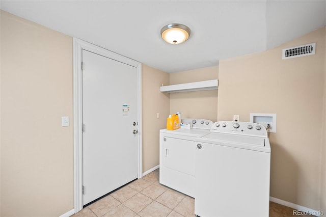 laundry room with washing machine and clothes dryer, light tile patterned flooring, laundry area, baseboards, and visible vents