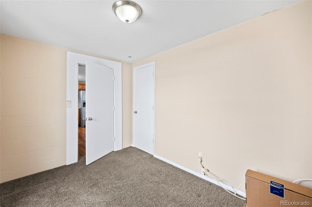 spare room with dark carpet