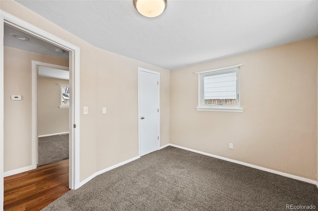 unfurnished bedroom featuring baseboards, carpet floors, and wood finished floors