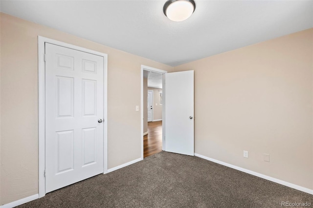 unfurnished bedroom featuring baseboards and carpet flooring