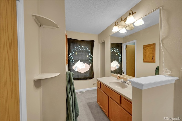 bathroom featuring vanity, a textured ceiling, and baseboards