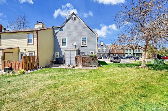 back of house with a yard, fence, and a chimney