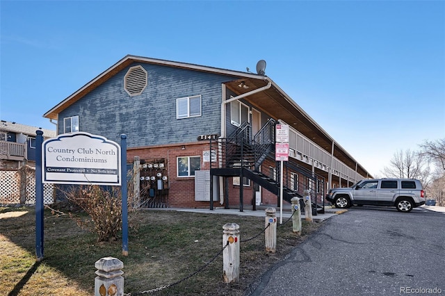 exterior space featuring brick siding and stairs