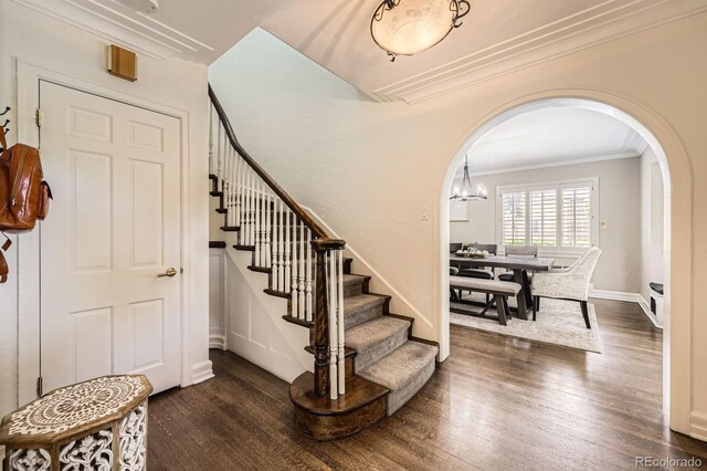 1000 N Monaco Pkwy, Denver, CO 80220 - stairs featuring arched walkways, ornamental molding, wood finished floors, baseboards, and a chandelier