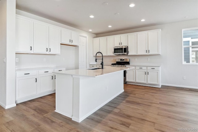 kitchen featuring white cabinetry, sink, an island with sink, and appliances with stainless steel finishes