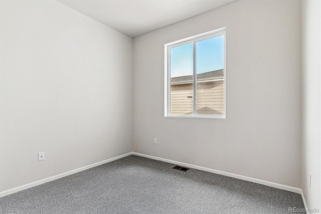 empty room featuring carpet floors, visible vents, and baseboards