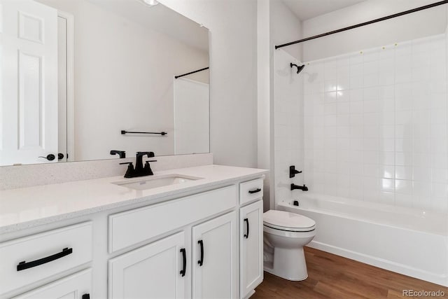 full bathroom featuring toilet, bathtub / shower combination, wood finished floors, and vanity