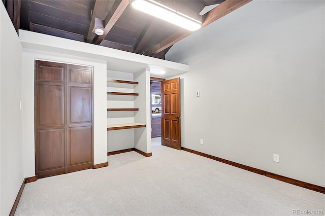 unfurnished bedroom with light carpet, lofted ceiling with beams, and wooden ceiling