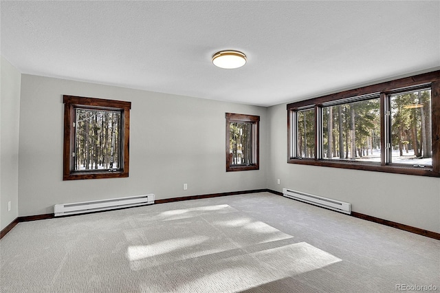 carpeted spare room featuring a baseboard radiator and a textured ceiling