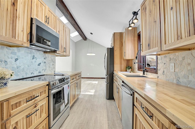 kitchen featuring pendant lighting, sink, decorative backsplash, light wood-type flooring, and appliances with stainless steel finishes