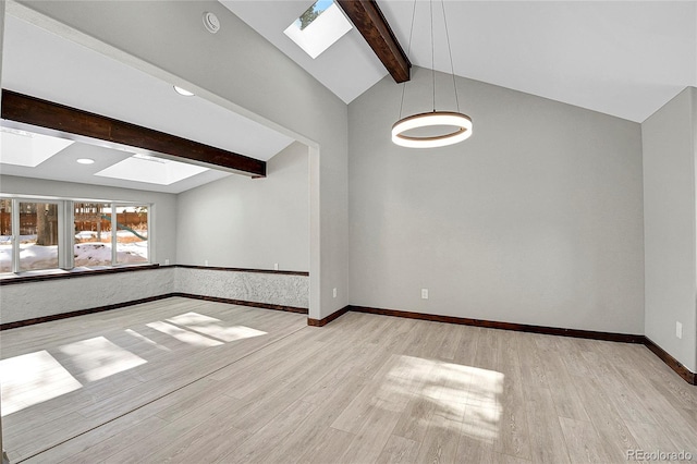 empty room featuring vaulted ceiling with beams and light hardwood / wood-style flooring