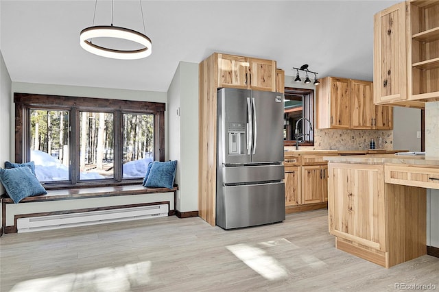 kitchen featuring light wood-type flooring, hanging light fixtures, stainless steel refrigerator with ice dispenser, and a baseboard heating unit