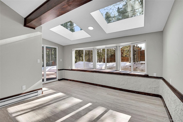 interior space featuring baseboard heating, lofted ceiling with skylight, and light wood-type flooring