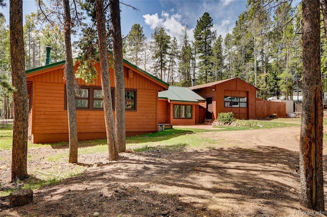 9123 Booker Ln, Conifer, CO 80433 - rear view of property with board and batten siding and driveway