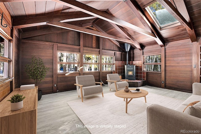 9123 Booker Ln, Conifer, CO 80433 - living room with wood walls, a wood stove, wood finished floors, lofted ceiling with skylight, and wooden ceiling