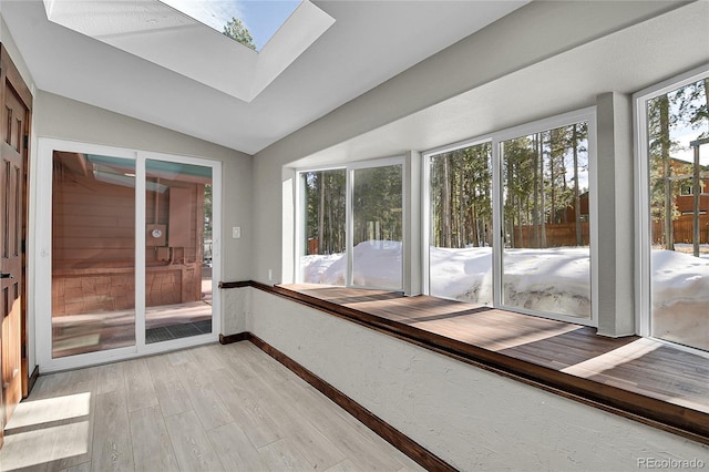 9123 Booker Ln, Conifer, CO 80433 - unfurnished sunroom featuring baseboards, wood finished floors, and lofted ceiling with skylight